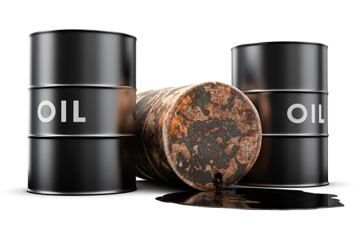 A leaking oil barrel spilling oil on the floor - stock photo